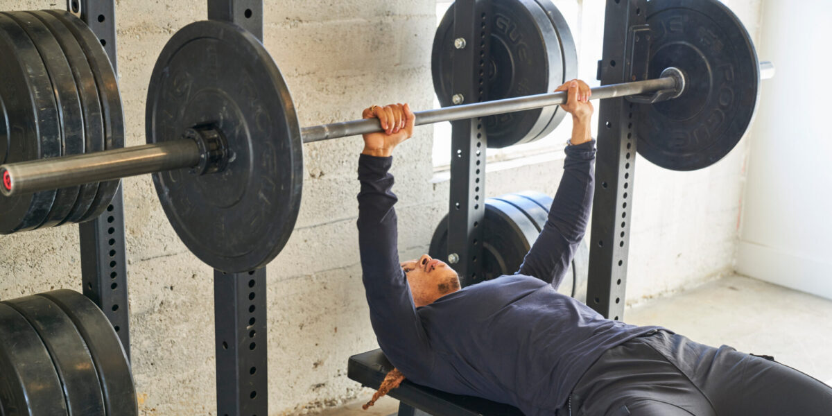 Man Finishing Bench Presses In Gym Hanging Weight On Rack Man Finishing Bench Presses In Gym Hanging Weight On Rack